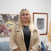 picture of Sarah in front of an Aboriginal painting